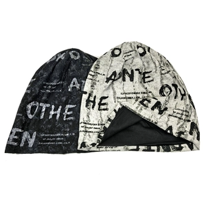 Close-up of distressed knit beanies with graffiti letter prints and washed texture