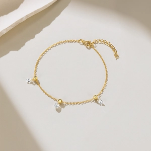 Macro detail of gold-plated S925 silver bracelet with pear-cut cubic zirconia pendants