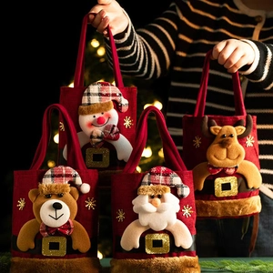 Detail of four festive red Christmas gift bags with 3D snowman, bear and Santa dolls