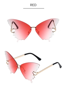 Macro detail of rimless butterfly sunglasses with red gradient lenses and golden metal arms
