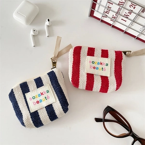 Detail of blue and red striped canvas mini makeup bags with metal zippers and cloth labels
