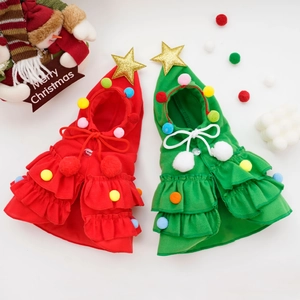 Detail of red and green pet Christmas capes with golden stars and colorful pom-poms