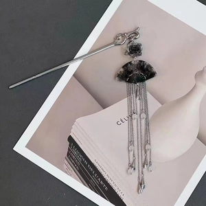Ink gradient fan hair pin with silver tassels and black marble finish on art books