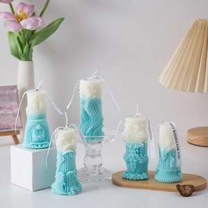 Detailed view of blue and white gradient roman pillar candles with elegant gift ribbons