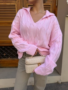 Detail of pink cable knit texture on a loose V-neck polo collar sweater for women