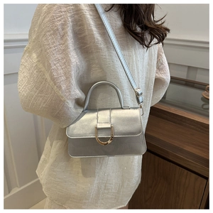 Detail of silver mini crossbody bag with gold D-ring buckle and adjustable strap