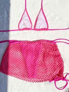 Detail of rose red bikini set featuring mesh wrap skirt and S size washing label