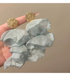 Macro shot of large blue chiffon flower earrings with textured golden metal discs
