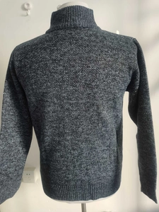 Detailed texture of dark grey knit sweater with high collar on display mannequin