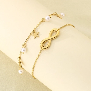 Détail du bracelet de cheville 18K orné de breloques étoile, perle et signe infini