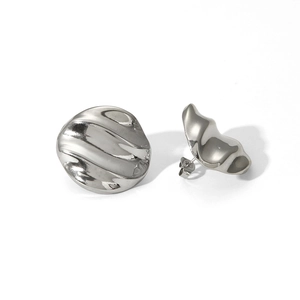 Macro detail of silver ripple textured stainless steel stud earrings with butterfly backings