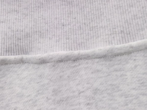 Detail of grey knitted fabric showing premium ribbed cuffs and fine stitching craftsmanship