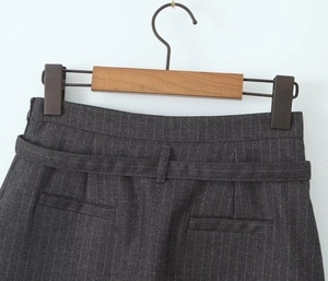 Detail of dark grey pinstripe skort with matching belt and fine suit fabric texture