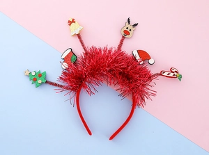 Détail d'un serre-tête de Noël rouge avec rennes scintillants, sapins et décors festifs
