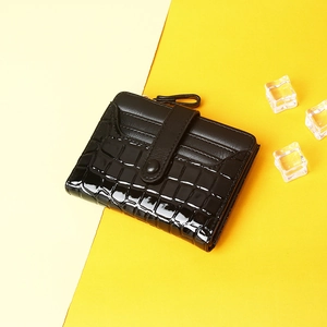 Short black crocodile pattern bifold wallet with snap closure on decorative ice background