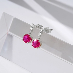 Detailed macro shot of vintage S925 silver earrings with red rubies on a prism