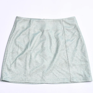 Vue détaillée du tissu bleu clair scintillant et des coutures de la mini-jupe