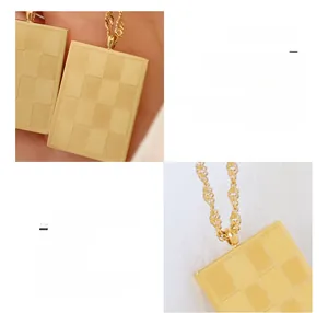 Detail of 18K gold plated checkerboard square pendant in durable surgical titanium steel