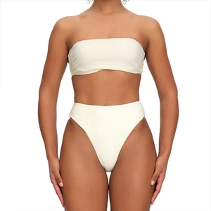 Detailed view of white two-piece swimsuit featuring a ruffled tube top and high-waist bottoms