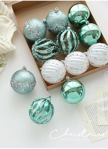Detailed view of mint green and white 8cm Christmas baubles with glitter and sequins in a box