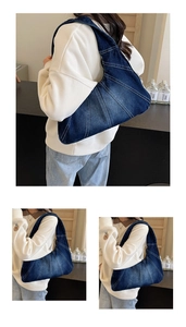 Détail du sac bandoulière en denim bleu foncé avec surpiqûres et forme triangulaire