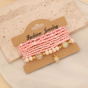 Detailed view of pink Bohemian beaded bracelets layered on a craft jewelry card