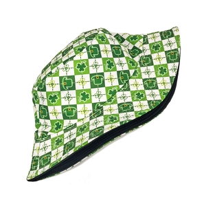 Macro detail of reversible bucket hat with green shamrock and checkerboard patterns