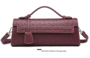 Detail view of the burgundy ostrich pattern leather surface on the handbag with top handle