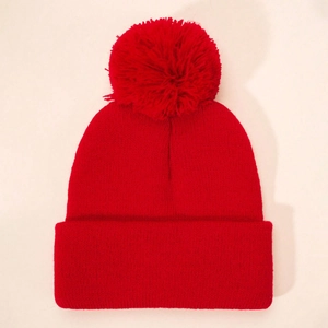 Kids' winter red knitted beanie with a large pom pom and wide cuff for warmth