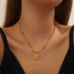 Elegant gold scallop shell pendant necklace with delicate beaded chain for women