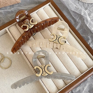 Detailed view of hair clips with metal buckle in deep brown, cream, and grey colors