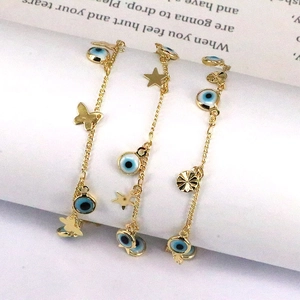 Golden multi-layer chain bracelet featuring evil eye, butterfly and star charms