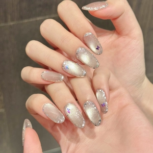 Detailaufnahme handgefertigter Katzenaugen-Drucknägel mit Glitzer und Schmetterling