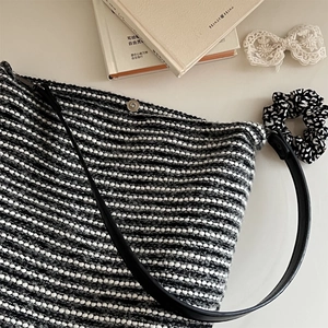 Détail du tissage en tweed noir et blanc avec fermeture magnétique argentée du sac