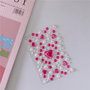 Detail of DIY 3D resin heart and white pearl stickers for scrapbooking decoration