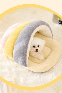Detail view of a shell-shaped cozy pet bed with soft velvet plush and a resting puppy
