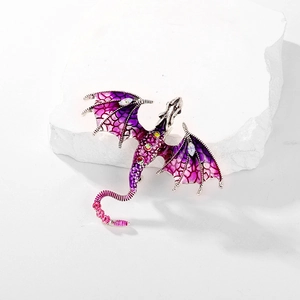 Close-up of purple enamel dragon brooch with sparkling rhinestones on stone base