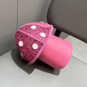Detail of pink mushroom handbag featuring red rhinestones and smooth leather finish