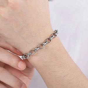 Close-up of polished stainless steel oval link chain bracelet on a model's wrist
