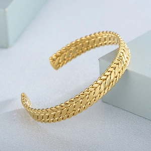Macro shot of gold-plated braided mesh pattern on the stainless steel cuff bracelet