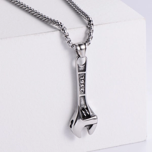 Macro shot of silver wrench pendant necklace in 316L stainless steel on a white background