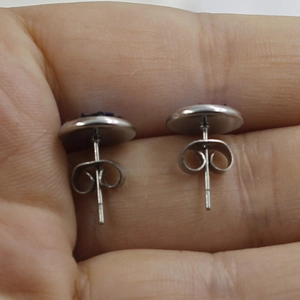 Close-up showing the back of 8mm stainless steel stud earrings with secure metal butterfly backs