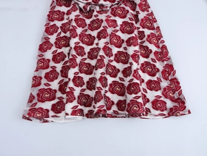Detail der roten Rosen-Jacquard-Muster und Beflockung am weißen Kleidersaum