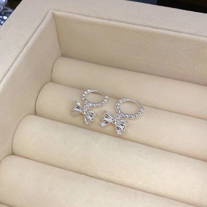 Silver metallic bow pendant hoop earrings in a minimalist geometric bead design