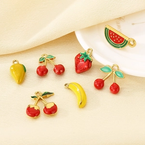 Detailed view of handmade enamel fruit charms including watermelon and strawberry