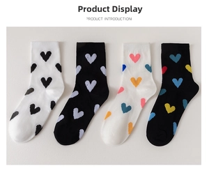 Detail view of cotton crew socks with pixel heart patterns in black and white colors