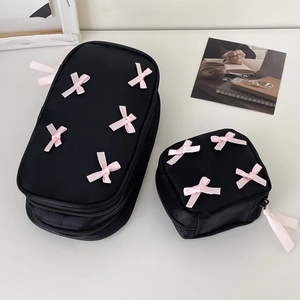 Black cosmetic bag set with decorative pink ribbon bows and aesthetic life card