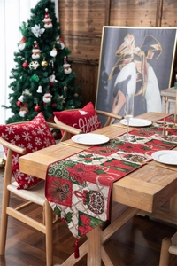 Detailed jacquard Christmas table runner with poinsettia, pinecones and red tassels