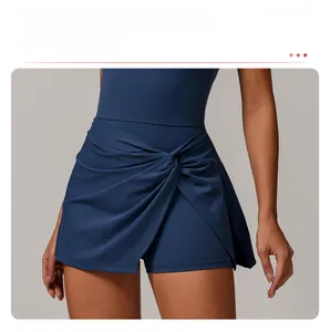 Close-up of the dark blue tennis skirt featuring a cross-knot hem and pleated layers