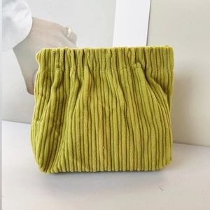 Detail of mustard green corduroy pouch with pleated texture and drawstring closure